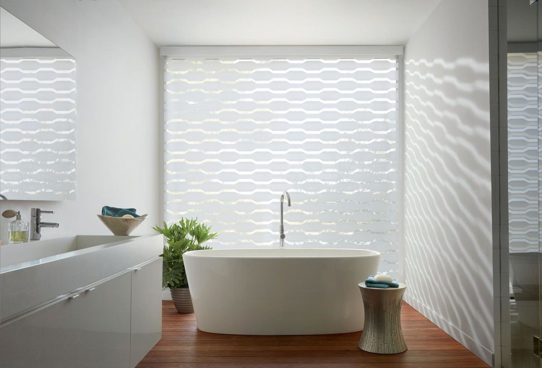 Who else is wishing they had a #bathroom like this to #unwind in the tub after a long week?⠀
⠀
Visit us today between 9:30 am and 5:00 pm and we'll get you started on your dream bathroom!⠀
⠀
Featuring #HunterDouglas Designer Banded Shades
