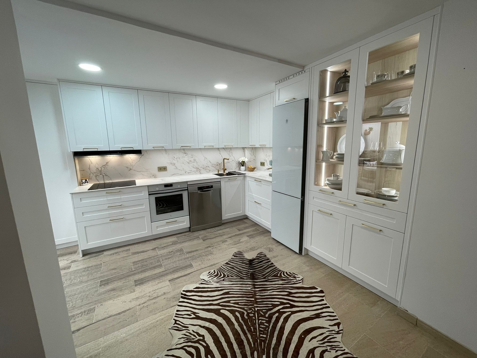 Elegancia y diseño atemporal.
La cocina de hoy tiene todo estudiado al detalle, nuestra clienta quería una cocina funcional, elegante, cómoda, con mucha zona de almacenaje, y todo con su toque personal.
Saliendo de la tendencia del uñero o perfil gola, se atrevió con un tirador de asa dorado, combinando también con dorado el grifo y el dispensador de jabón de @icoben.cocinas.
El modelo de puerta lacado en acabado blanco seda da ese toque cálido y luminoso, y como elemento que acapara casi todo el protagonismo de la estancia, dándole más elegancia, el mueble vitrina con interior en roble crudo iluminado con luces led.
La encimera no podía ser menos, y el porcelánico @dektonbycosentino Entzo Mate con esa veta tan bonita, es un acierto seguro para esta combinación.
Y como complemento perfecto, los electrodomésticos Balay.
Atendemos con cita previa 📞 ☎️
Visita nuestra página web 📱
#mundococina #cocinascordoba #cocinasvilladelrio #cocinasblancas
#cocinasnegras #madera #mobiliario #cocinas #cocina
#mueblesamedida #carpinteria #deco #decoración #reformas #kitchen
#muebles #mueblesdecocina #cocinasmodernas #interiorismo #hogar
#interiordesign #diseñodeinteriores #baños #armarios
#armariosempotrados #vestidores #home #armariosamedida #electrodomésticos